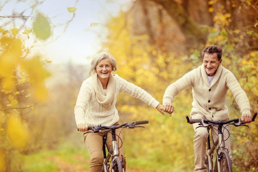 Pareja de la tercera edad cuidando sus articulaciones yendo en bici