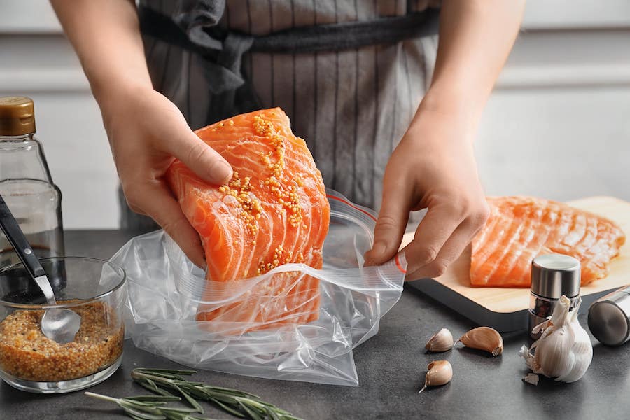 Mujer cocinando salmón, fuente de Omega-3